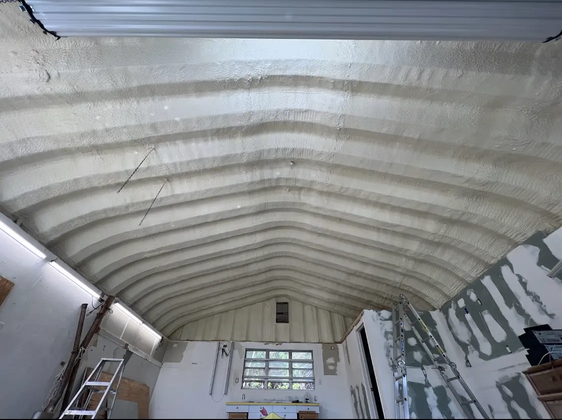 Spray polyurethane foam applied to the underside of a metal roof deck in Lysander